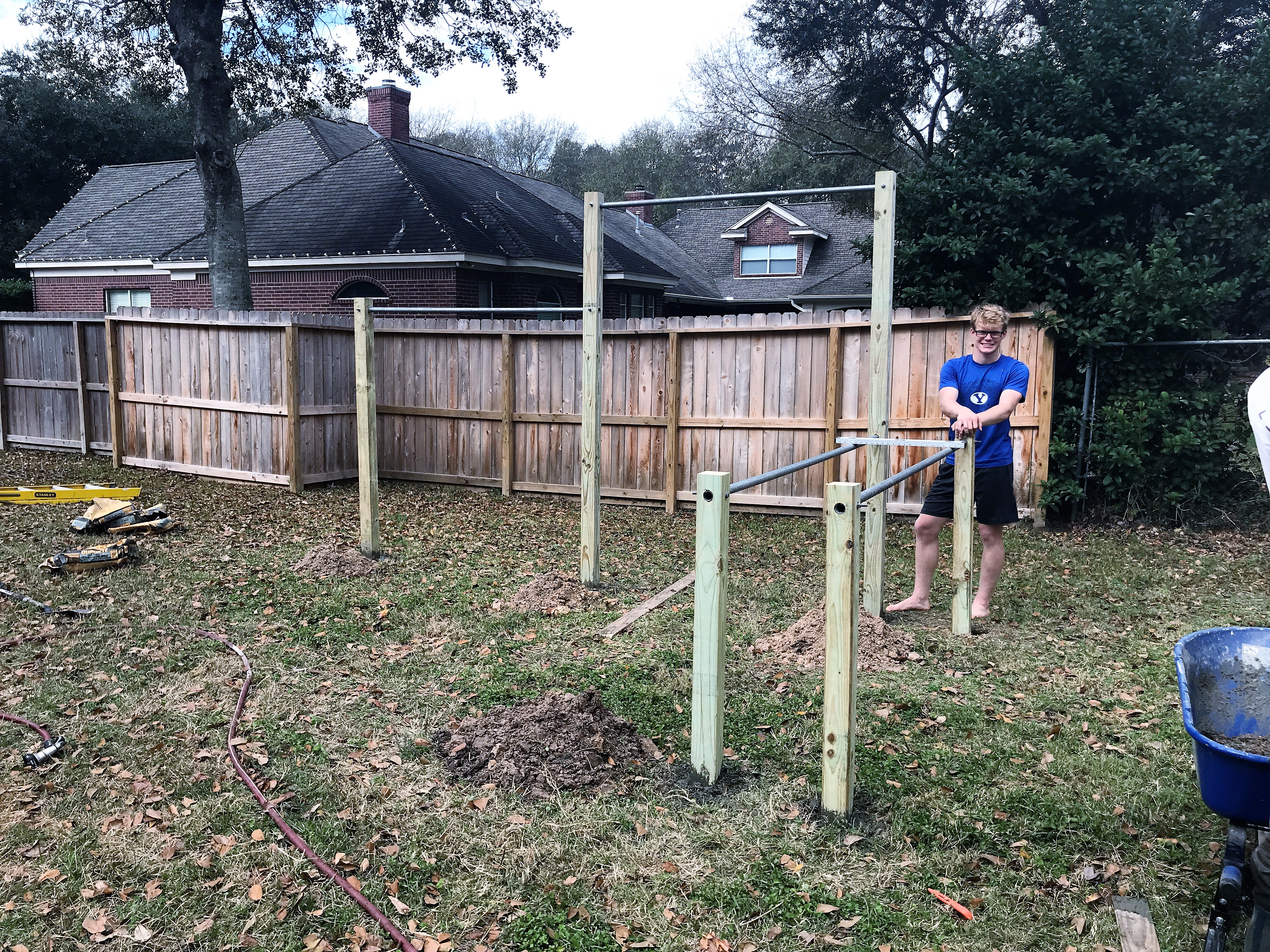 Completed backyard pull-up bar structure set in concrete and ready for use.